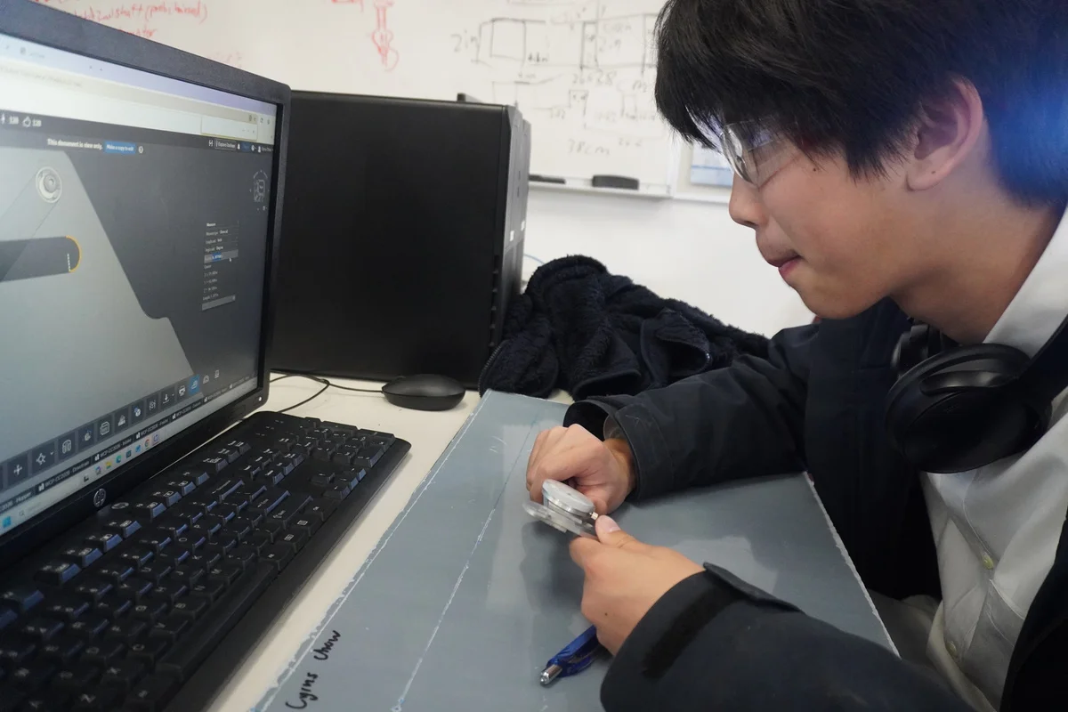 A team member working on a design at a laptop.